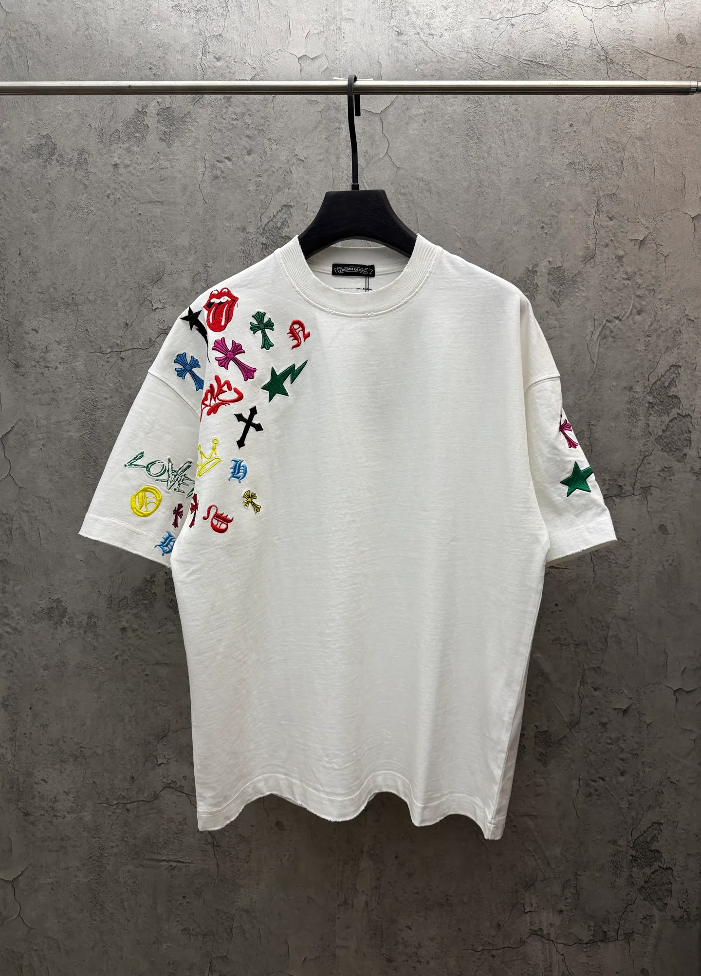 P240 top version, real shot without P, ​​different from market currency) 𝗖𝗵𝗿𝗼𝗺𝗲 𝗛𝗲𝗮𝗿𝘁𝘀/Cro Heart 2026 Spring New Original Single Counter American Color Thread Embroidery Couple Short Sleeves 👑The highest version! Customized fabric 320 grams, best-selling model at the counter, very comfortable to wear. Accessories: original molded and authenticated collar label ➕ 100% silk wash water label. Genuine purchase-grade original hangtag➕matching hanging rope➕3D hanging beads➕original packaging bag. Craftsmanship: The original version has consistent wiring! The highest version of the armhole matching technique! Color: White Black Size: S M L XL Style No.: 5211